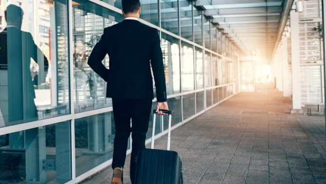 Man pulling a suitcase outside the airport representing duty of care obligations when travelling. 