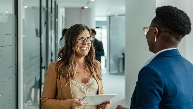Two people in an office discussing Flight Centre's EOFY results.
