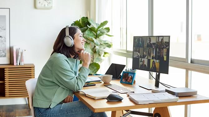 Woman in a virtual meeting, representing remote and hybrid workers connecting for offsite events.
