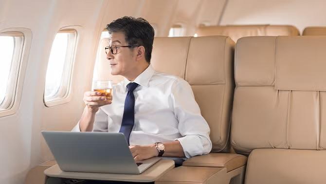 Man sitting in first class highlighting business and first class travel among Australian corporates grew by 43% in 2023. 