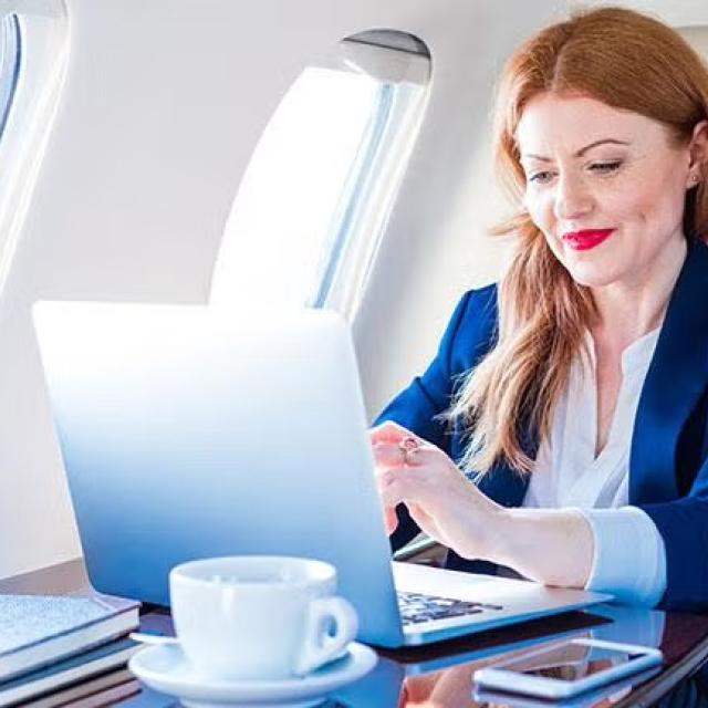 Woman sitting in first class on an airplane representing what’s on offer in Virgin Australia’s and Qantas’ corporate loyalty programs