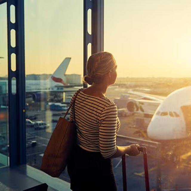 Women looking out of airport window representing mistakes your business should avoid when booking travel.